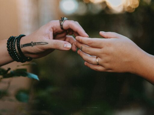 duas mãos tatuadas se tocando